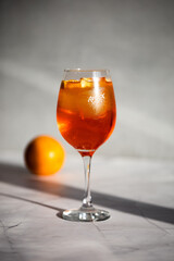 photography of aperol spritz cocktail glass with orange slice photo taken with light and shadow
