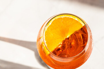 close up of aperol spritz cocktail with orange slice and ice
