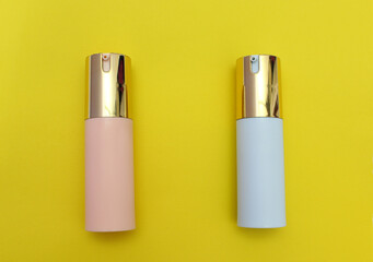 Envases de plastico en color azul y rosa con tapas doradas. 