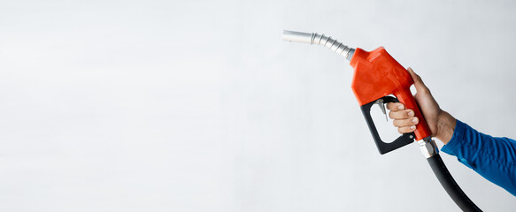 Person holding a gas nozzle on a white background, fuel consumption, petrol-fueled cars,...
