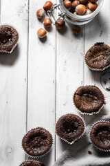 Top vie flat-lay chocolate muffins with nuts on white wood table