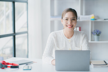 Asian woman enjoy listening to music and drinking coffee and laptop computer in the morning