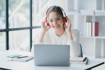 Asian woman enjoy listening to music and drinking coffee and laptop computer in the morning