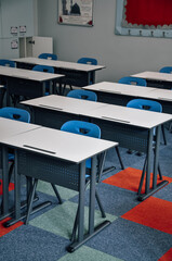 Empty classroom and school with wooden table and iron chair for primary education, education...