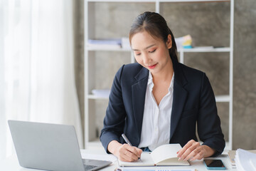 business woman or accountant who are using a calculator to calculate business data Accounting documents and laptop computer at the office business idea