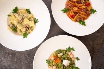 three of pasta on a gray background, top view.