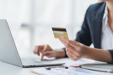 Happy asian Business woman pay online using mobile phone at the office.