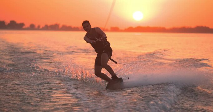 Wakesurfer rides a board on a lake