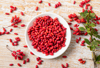 Pile of Berberis vulgaris also known as common barberry, European barberry or barberry on plate in home kicthen. Edible herbal medicinal fruit plant.