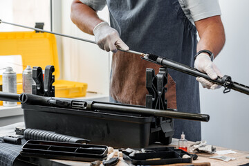 Close up of a gunsmith cleaning firearm barrel with ramrod brush