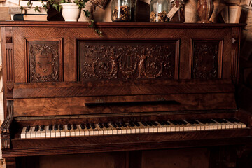Fototapeta na wymiar An old piano in a dark room. Lots of books on the walls
