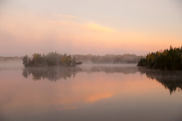 Naklejka na ściany i meble fog in the early morning on an autumn forest lake