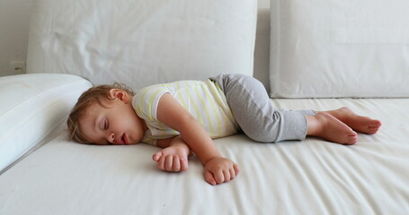 Adorable baby boy asleep in home sofa nap. Cute toddler dreaming. Infant sleeping