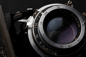 Fototapeta na wymiar close up detail shot of an old analog film camera lens on isolated black background hobby photography illustration ideas