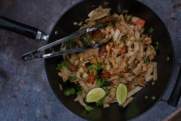 Vegan pad thai made with tofu, seitan, mushrooms and carrot served in wok, copy space