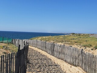 Wooden jetty on the beach on the Atlantic Ocean with sea and sun