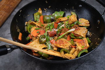 Vegan tofu skins, carrot and pepper stir fry in wok