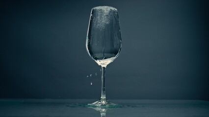 Pure water overflowing glass closeup. Cool refreshing liquid spilling wine cup