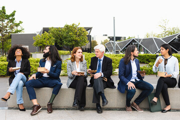Multiracial business people with different ages having a lunch break outside office