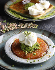 Oriental sweets. Pahlava with ice cream nuts, pistachio in a large dish on a black table. Turkish dessert. Background image, copy space, horizontal