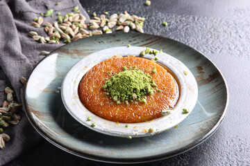 Oriental sweets. Pahlava with nuts, pistachio in a large dish on a black table. Turkish dessert. Background image, copy space, horizontal