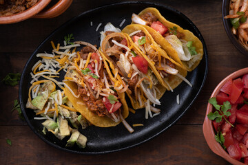 Mini street vegetarian corn tacos and side filling: tomatoes, queso, avocado, refried beans