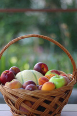 Vintage basket full of seasonal fruit in the garden. Selective focus.