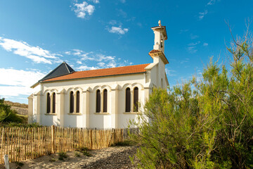 White church with red roof on the beach in the South of France