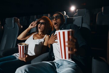 A young couple came to watch a movie with popcorn.