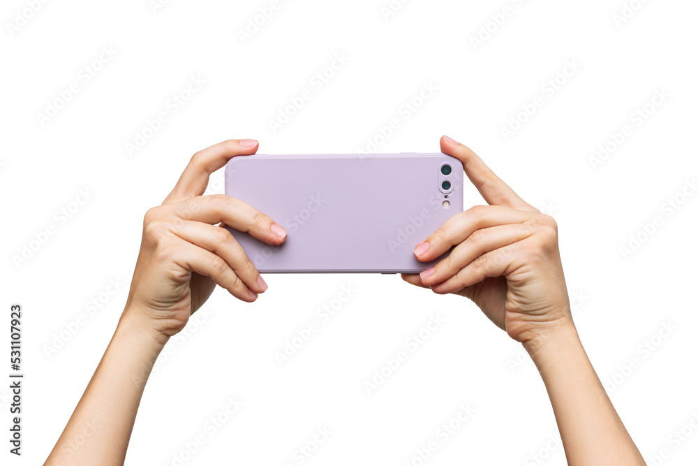 Wall mural Mobile phone with photo camera in a lilac case in female hands isolated on a white background. Blank with an empty copy space for the design. Mockup of a smartphone. A young woman takes picture