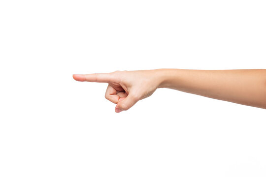 A young woman's hand points to the side at a copy empty blank space for text and design isolated on a white background. Pointing finger gesture