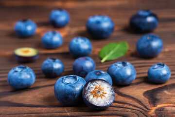 Fresh blueberries with leaves on wooden background