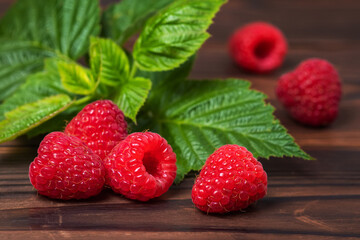 Ripe Sweet Raspberries on the Wooden Table Against the Heap of Summer Fruits and Berries