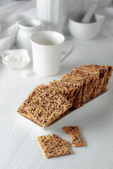 Crackers with sunflower seeds and flax seeds on a white table.