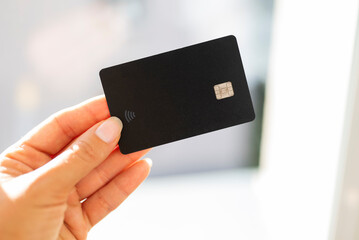 black bank credit card template for contactless payment in the girl's hand