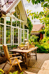 wooden table in the courtyard of the country house with retro decor elements.