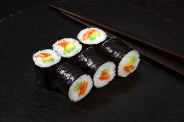 Set of tuna and avokado sushi rolls on black desk background