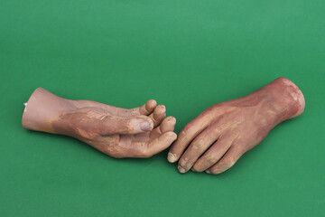 Artificial hands on green background.