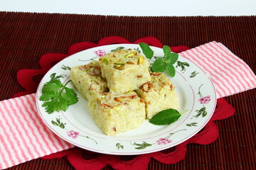 indian gujarati traditional sweet or mithai dudhi halwa or burfi pak made from bottle gourd (dudhi lauki) in dish with dry fruit garnish