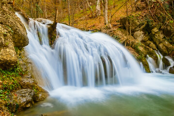 Fototapeta na wymiar closeup small waterfall on mountain river, mountain canyon autumn landscape