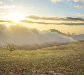 mountain plateau in dense mist and clouds at the sunset