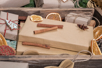 Fototapeta na wymiar Wrapping rustic eco Christmas packages with brown paper and string on dark background
