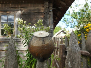 old wooden fence with clay pots in a belarusian village