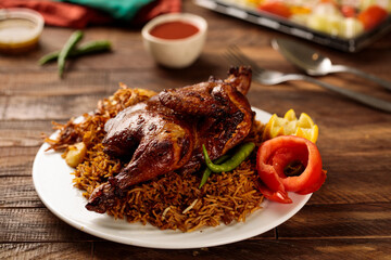 Machboos chicken or chicken biryani with tomato sauce and salad served in a dish isolated on wooden...