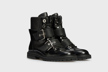 Black women's fashion glossy combat boots isolated on white background. Female classic spring autumn shoes. Leather laced casual footwear with rivet, buckle. Mock up, template