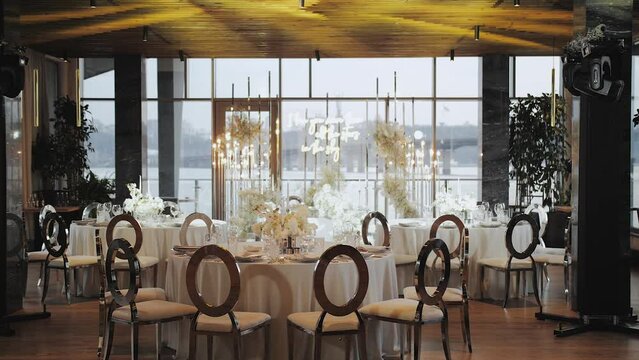 Beautiful wedding decor, all decorated in pastel colors, camera moving slow motion. Festive served plates and glasses on the table.