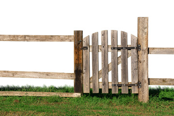 An old wooden fence with a closed gate on the green grass.
