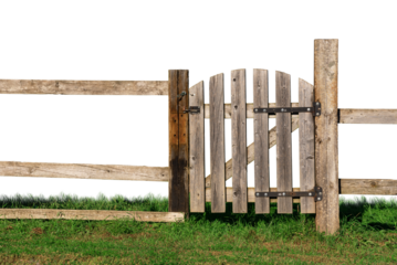 An old wooden fence with a closed gate on the green grass.