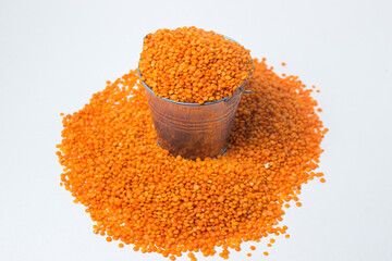 Red lentils in a small bucket on a white background. Delicious vegetarian food