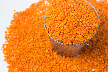 Red lentils in a small bucket on a white background. Delicious vegetarian food